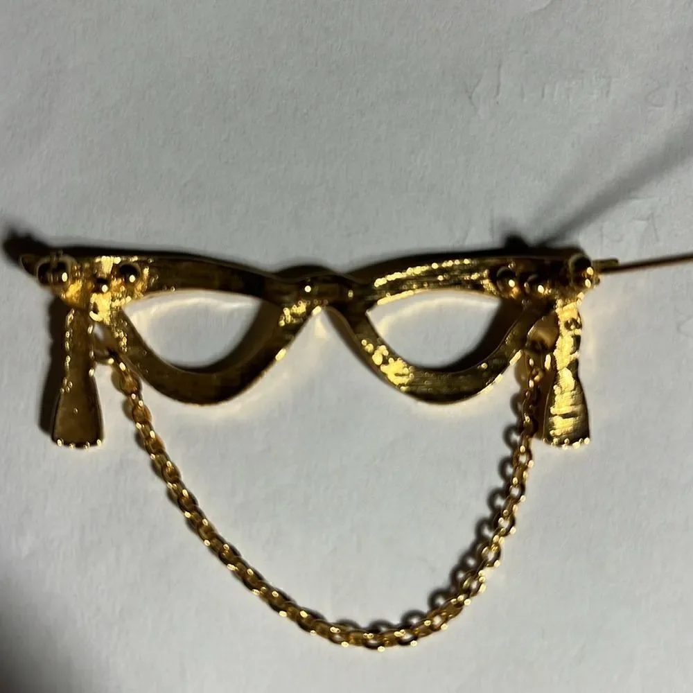 Avon golden eyeglass holder brooch with gold tassel.